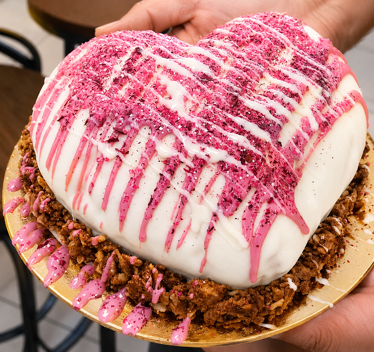 Heart-shaped white chocolate gelato cake with pink drizzle and a caramelized crunch base